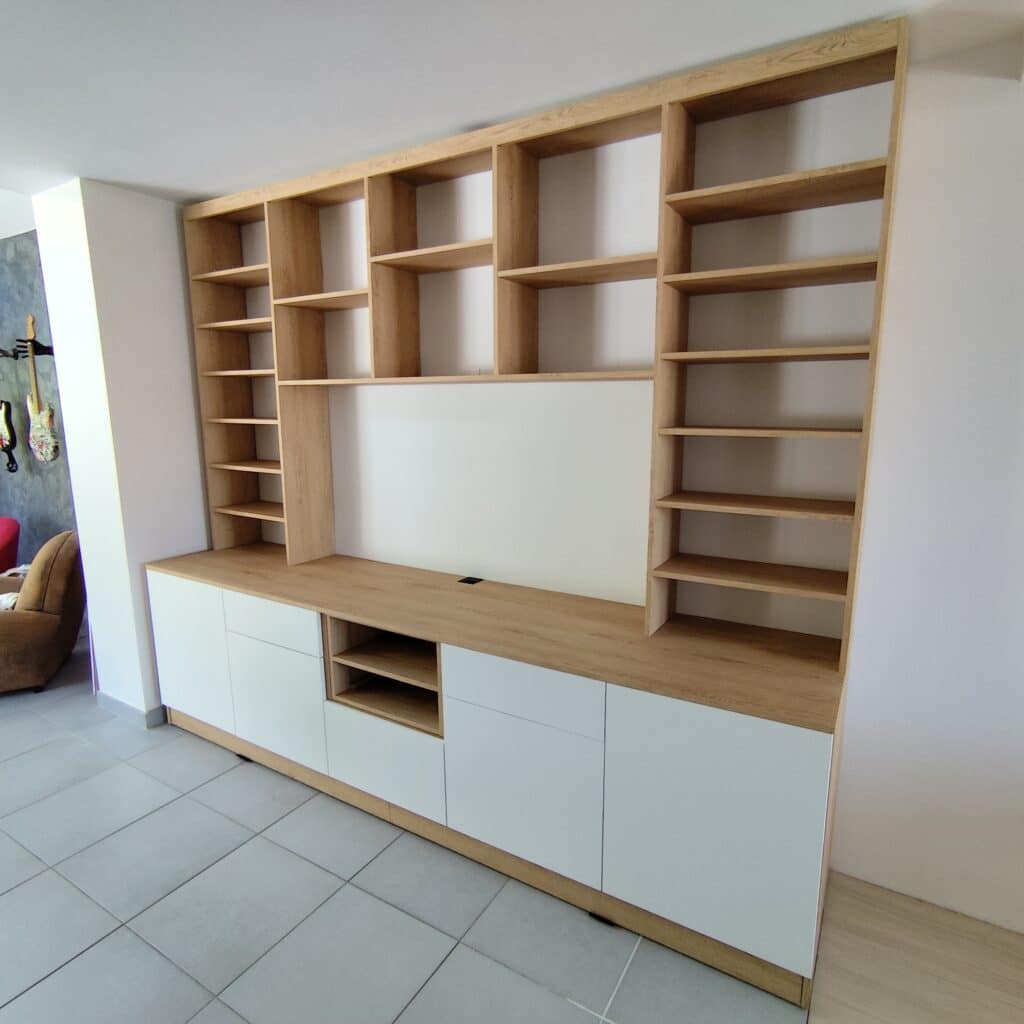 Meuble TV mural bois clair & blanc | Design moderne pour salon Meuble TV mural sur mesure, bois clair et blanc. Étagères intégrées et rangements bas fermés pour salon moderne.